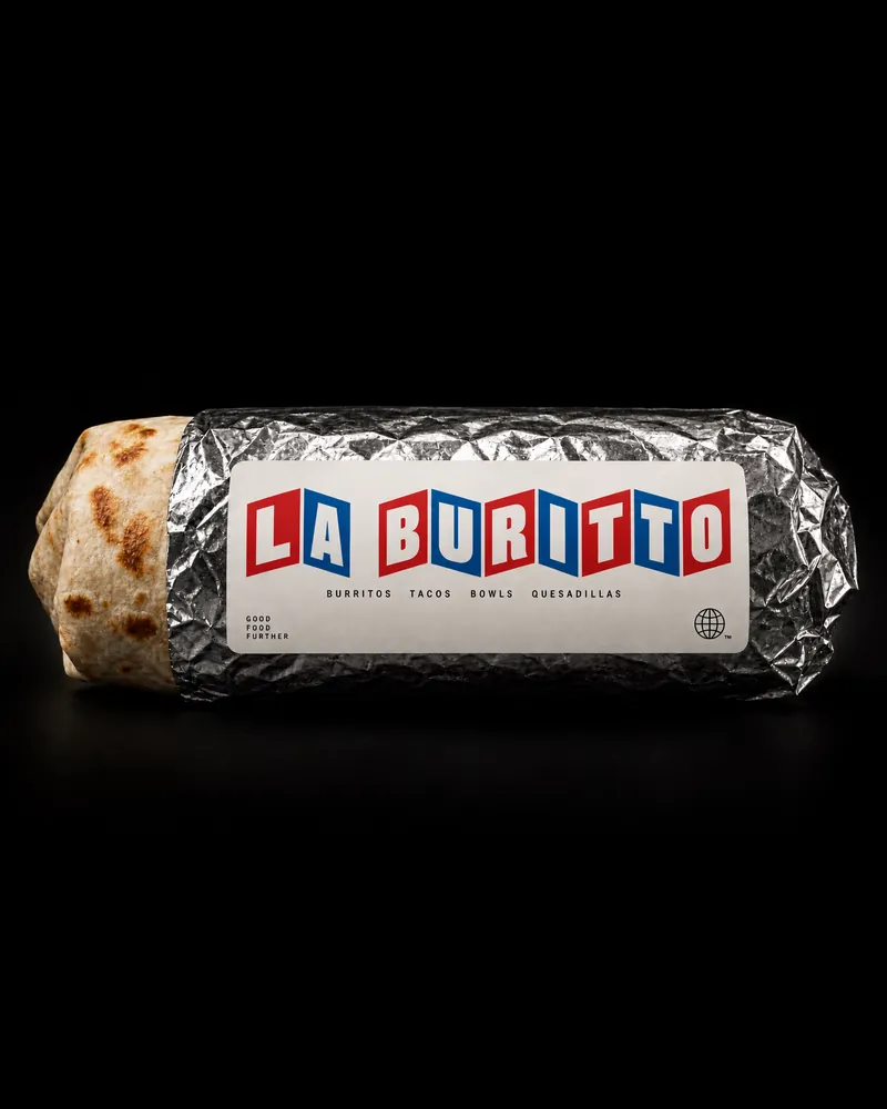 A LA BURITTO burrito wrapped in crumpled foil with a white LA BURITTO label, its grill-marked tortilla end showing, on a black studio background.